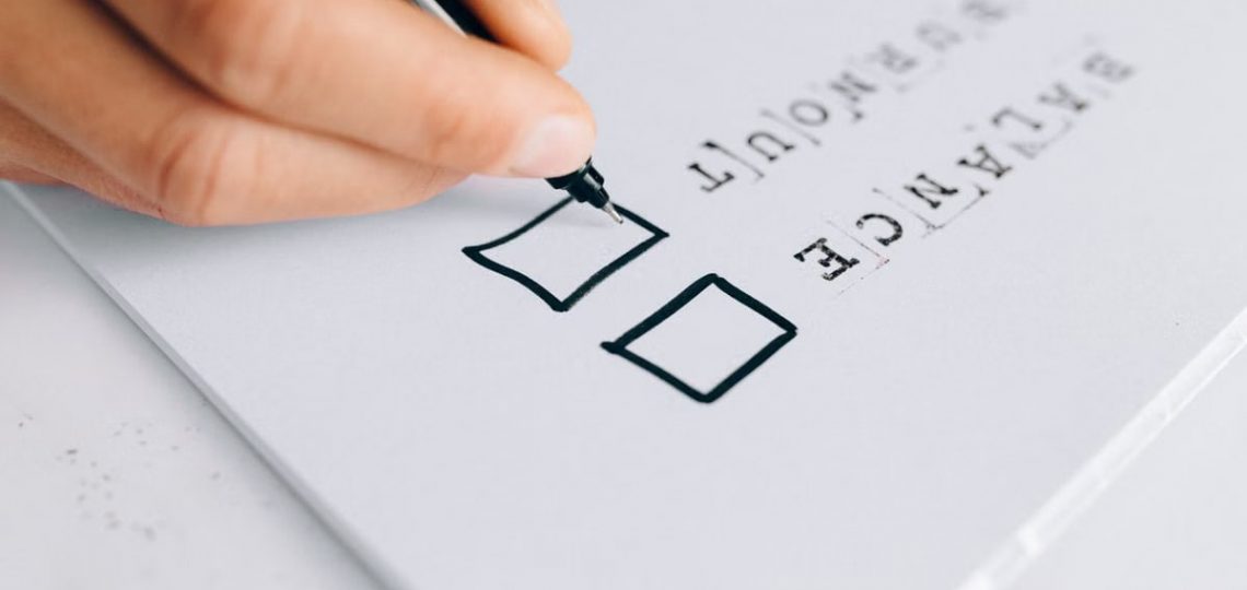A hand drawing checkboxes on a checklist, themed around balance and burnout.